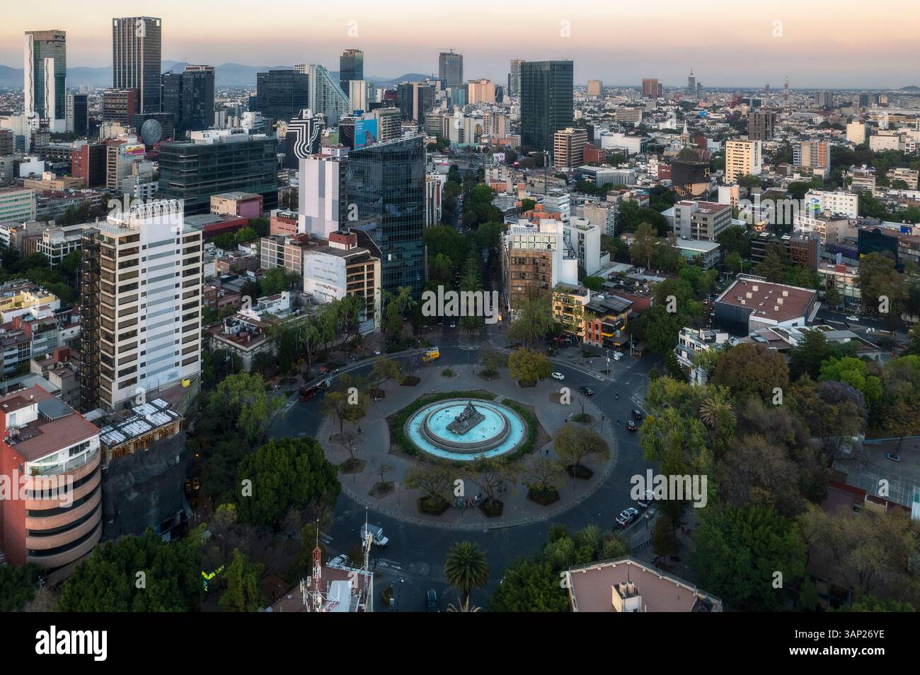 Vista aerea di fuente de cibeles circondata da edifici moderni e lussureggiante vegetazione al tramonto, Cuauhtemoc, città del Messico, Messico. Foto Stock