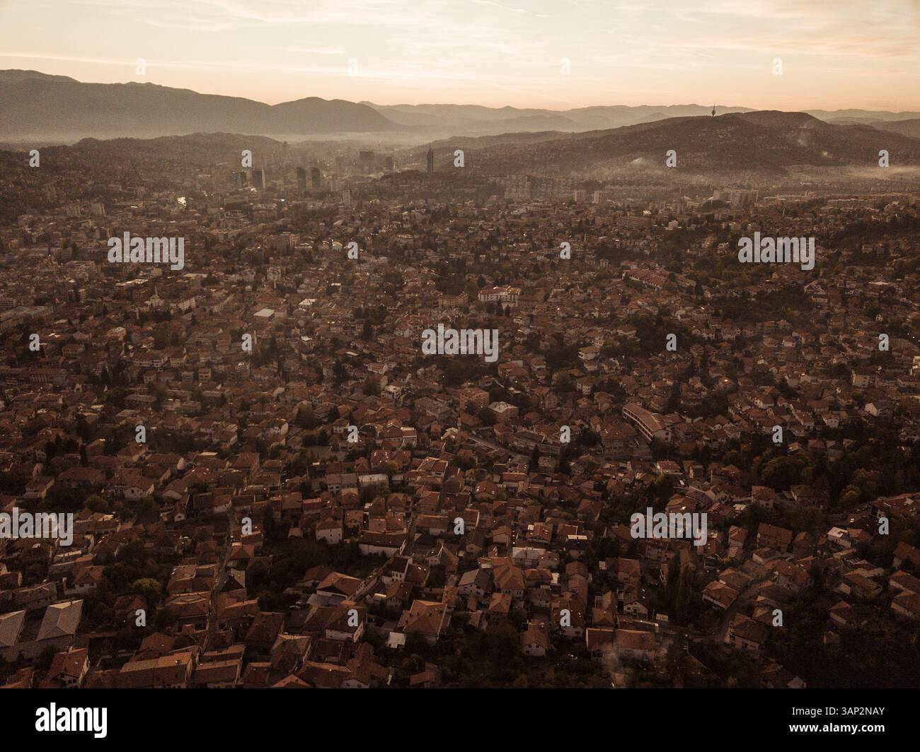 Vista aerea di splendidi paesaggi urbani con edifici storici e montagne al tramonto, Stari Grad, Sarajevo, Bosnia ed Erzegovina. Foto Stock