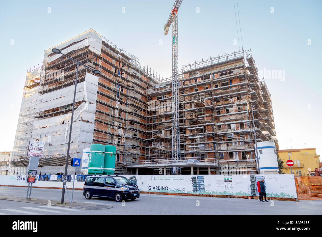 Sottomarina, Italia - 3 marzo 2025: Cantiere di un nuovo complesso residenziale con ponteggi e gru in fase di riqualificazione urbana Foto Stock