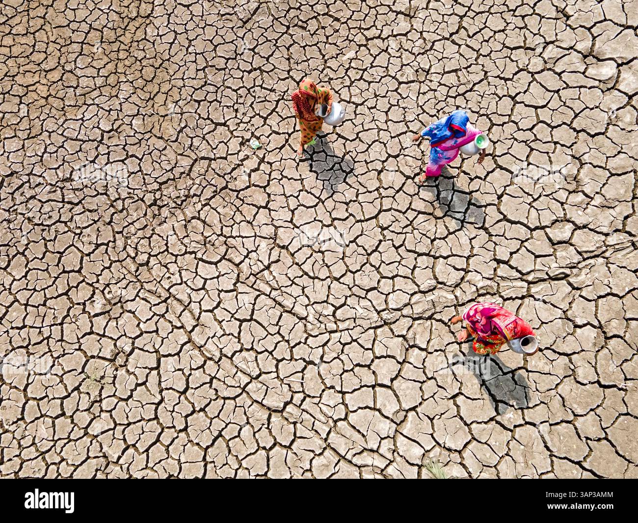 Vista aerea della terra incrinata colpita dalla siccità con persone che raccolgono acqua in un villaggio costiero, Khulna, Bangladesh. Foto Stock