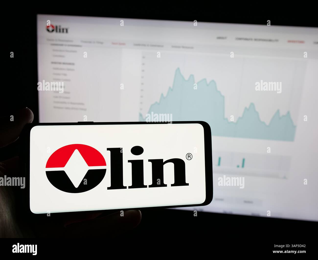 Stoccarda, Germania - 12-09-2024: Persona che possiede uno smartphone con il logo della società chimica statunitense Olin Corporation sullo schermo davanti al sito web. Foto Stock