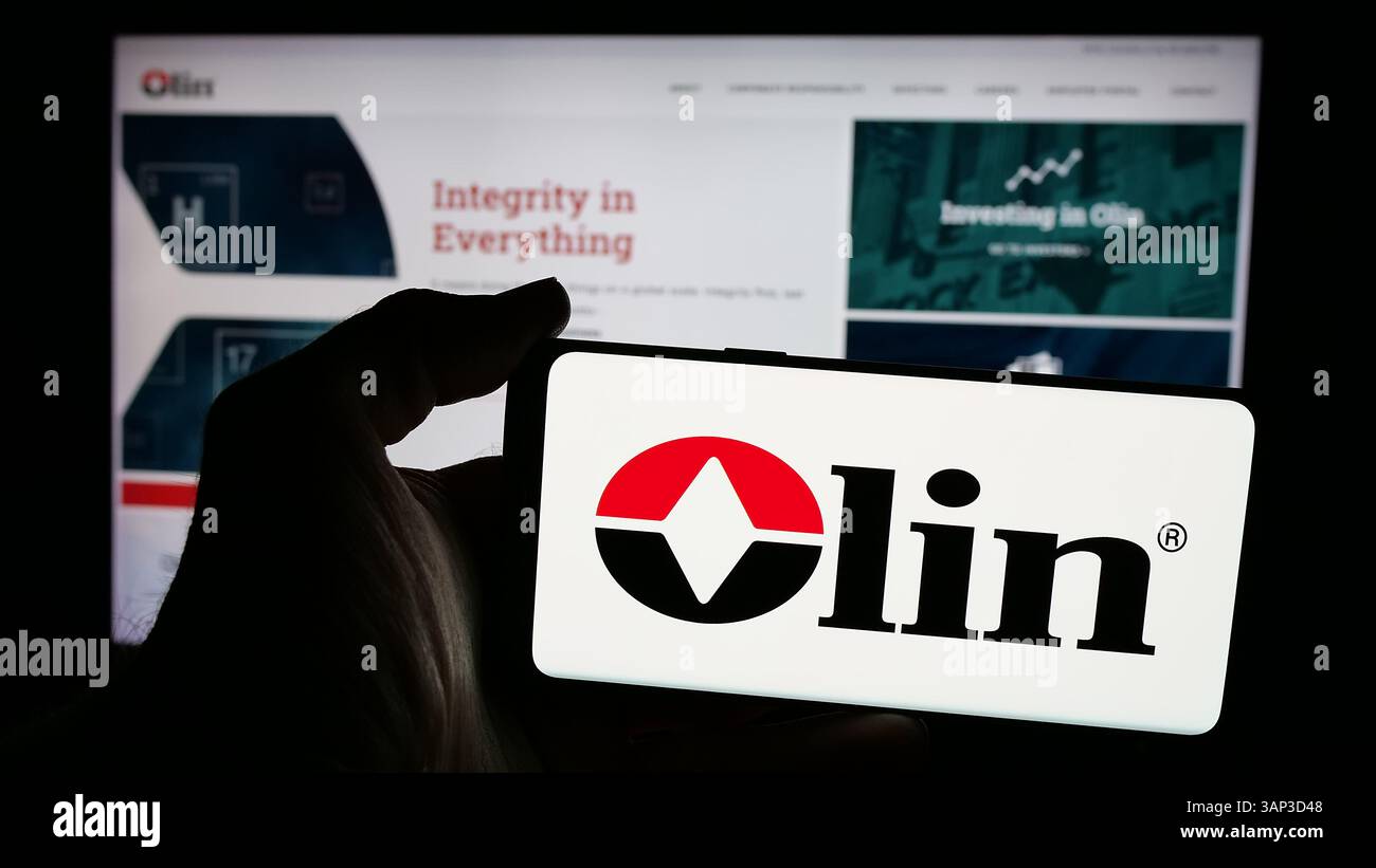 Stoccarda, Germania - 12-09-2024: Persona che detiene un telefono cellulare con il logo della società chimica americana Olin Corporation sullo schermo di fronte alla pagina web. Foto Stock