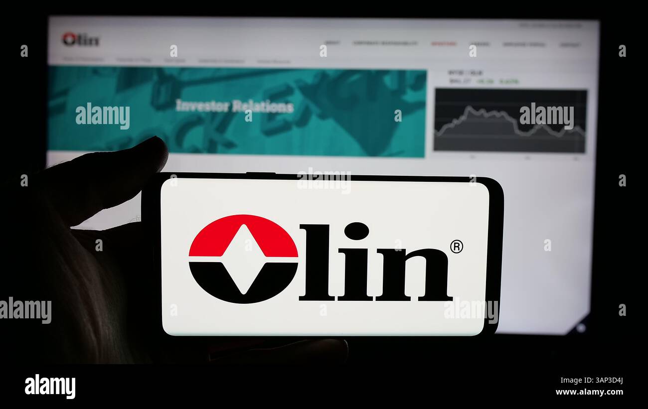 Stoccarda, Germania - 12-09-2024: Persona che detiene un cellulare con il logo della società chimica statunitense Olin Corporation sullo schermo di fronte alla pagina web aziendale. Foto Stock