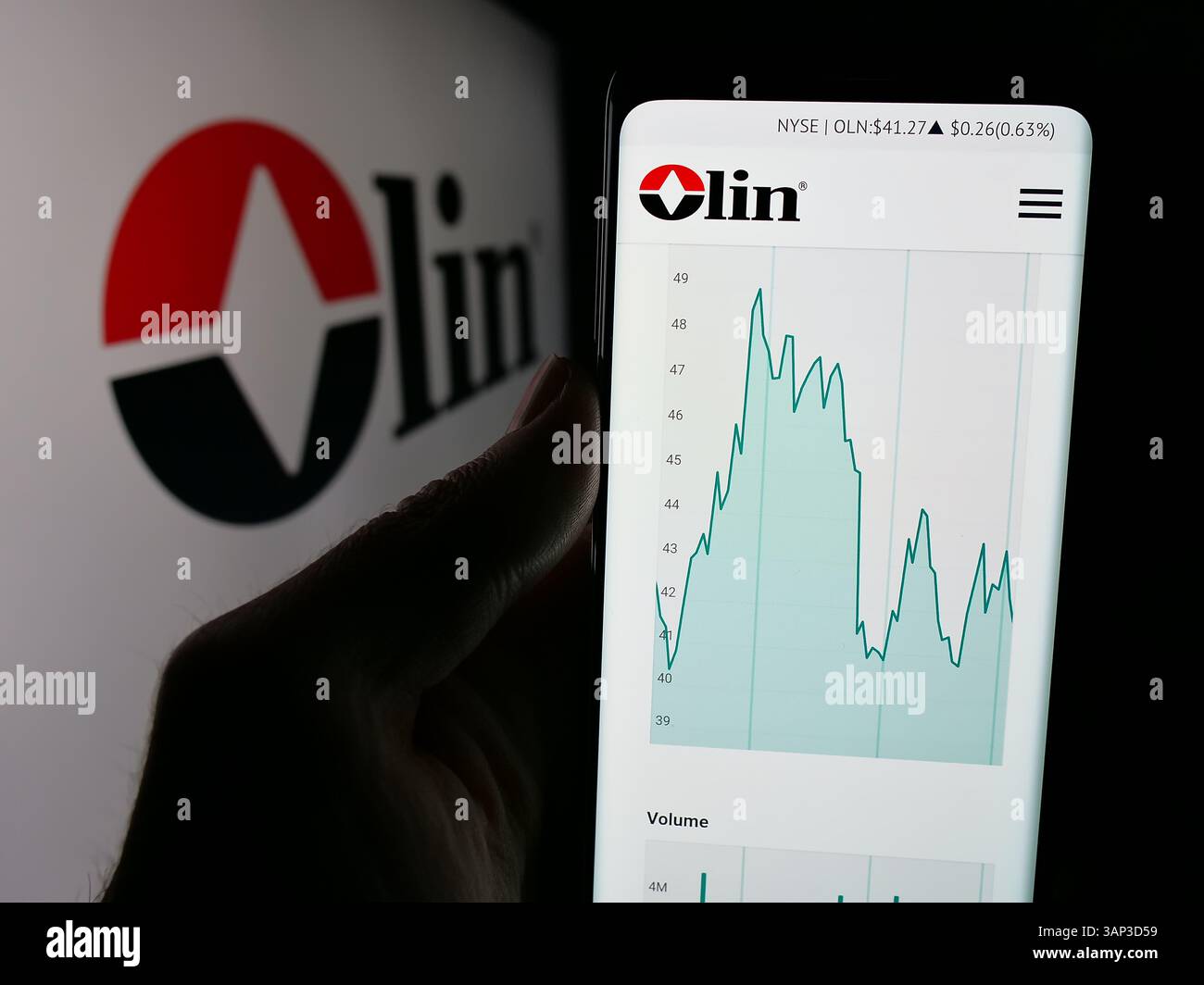 Stoccarda, Germania - 12-09-2024: Persona che possiede uno smartphone con pagina web della società chimica statunitense Olin Corporation sullo schermo davanti al logo. Foto Stock
