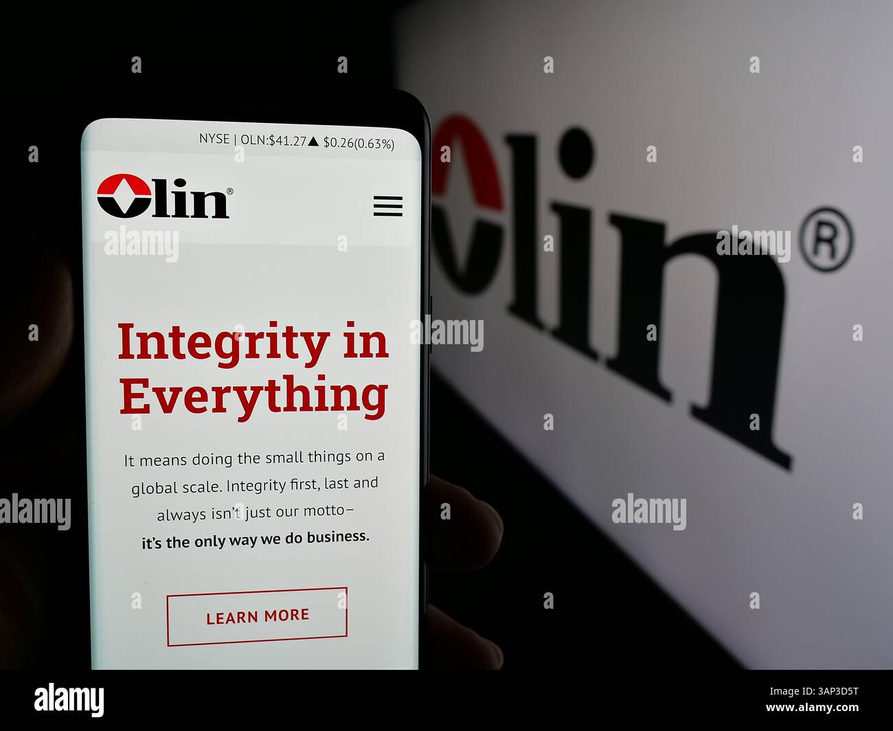 Stoccarda, Germania - 12-09-2024: Persona che detiene un cellulare con pagina web della società chimica statunitense Olin Corporation sullo schermo davanti al logo. Foto Stock