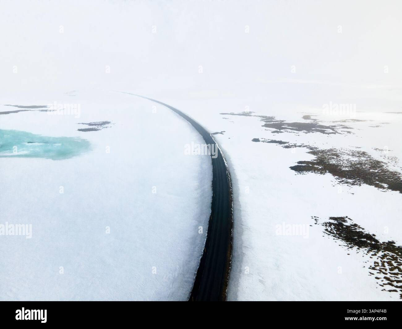 Vista aerea di una strada invernale circondata da neve e ghiaccio, Holmavik, Islanda. Foto Stock