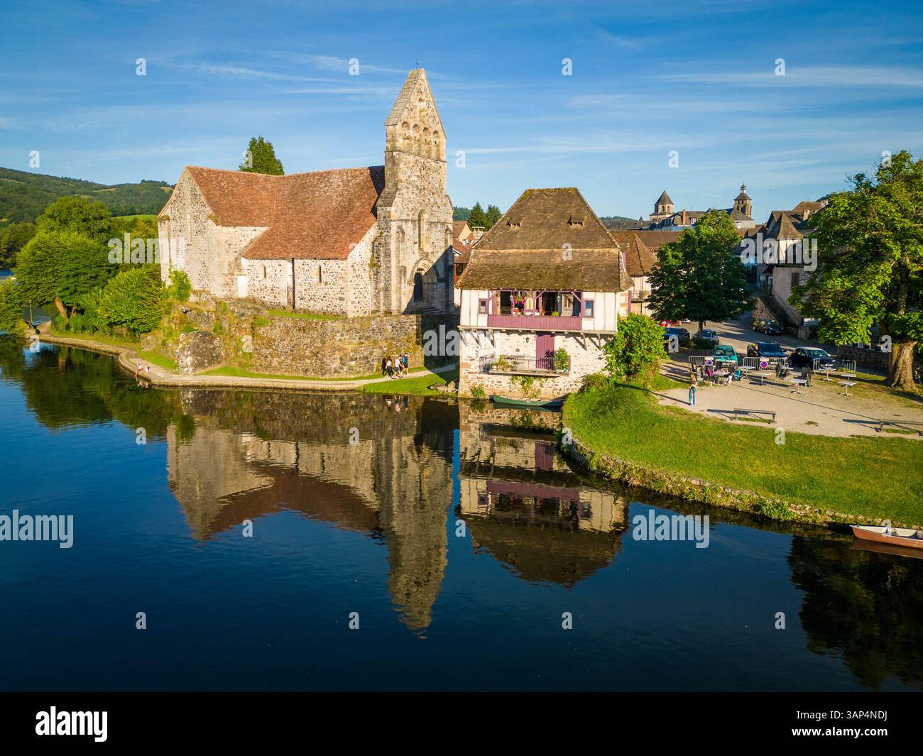 Vista aerea della pittoresca città vecchia con edifici storici e un fiume tranquillo che riflette il cielo, Beaulieu sur Dordogne, Francia. Foto Stock