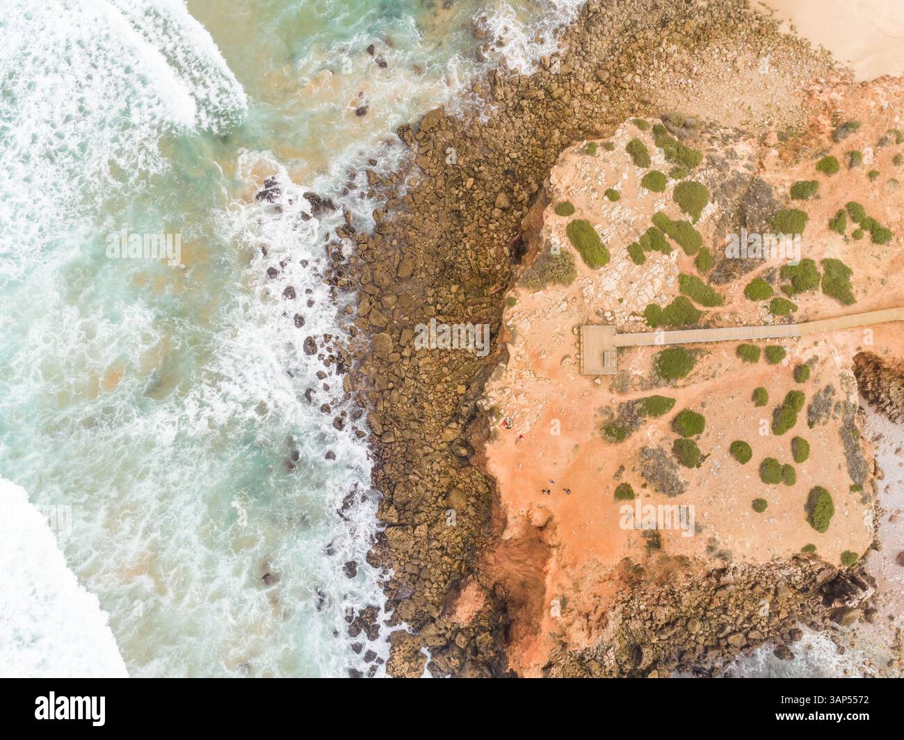 Vista aerea delle forti onde che colpiscono la riva a Praia da Bordeira, Carrapateira, Portogallo Foto Stock
