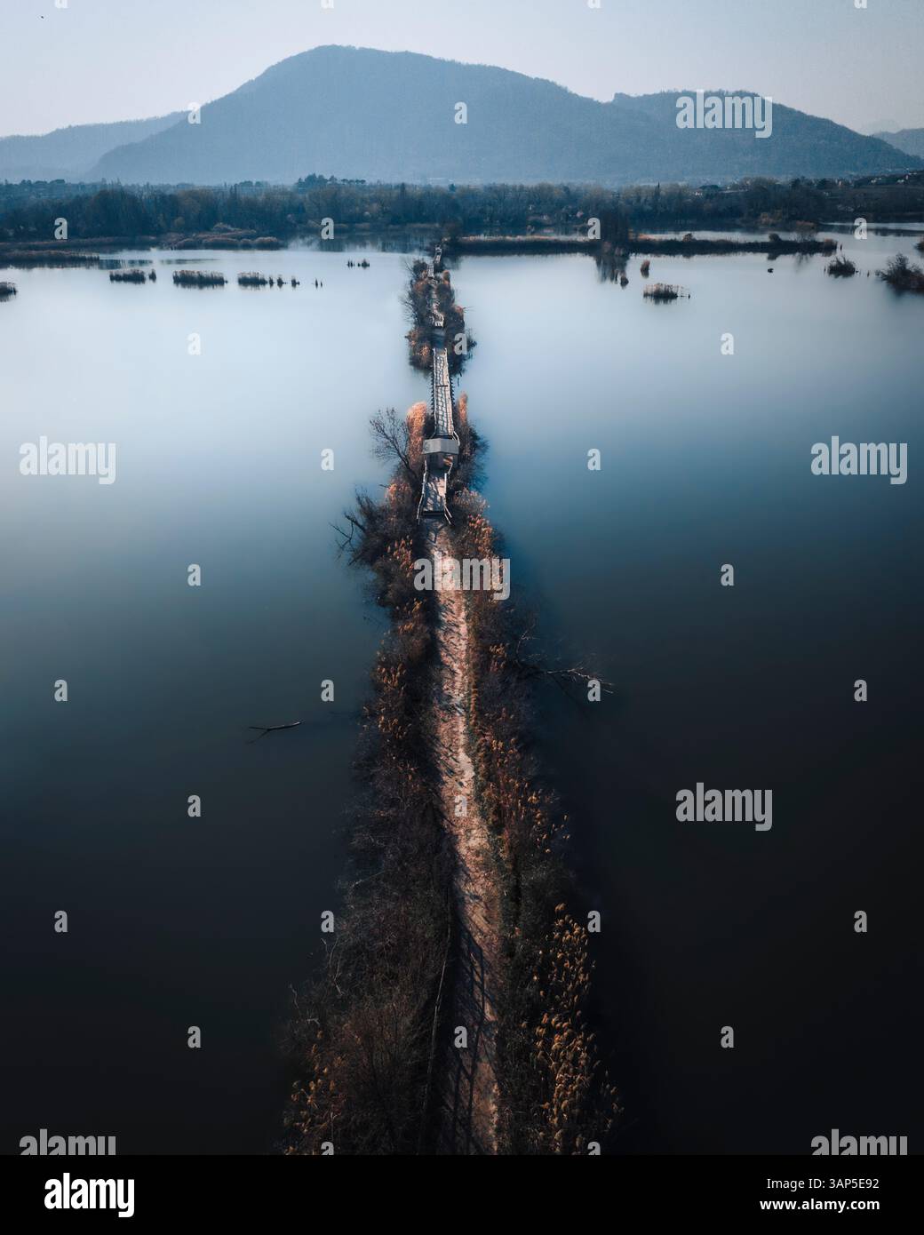 Vista aerea di un tranquillo ponte in legno nel mezzo di un tranquillo lago circondato dalle montagne, Torbiere del Sebino, Provaglio d'Iseo, Brescia, Italia. Foto Stock