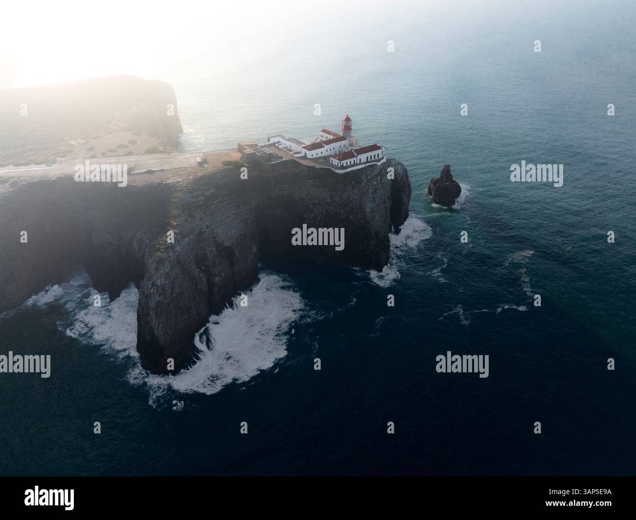 Vista aerea del maestoso faro in cima alle aspre scogliere che si affacciano sul tranquillo Oceano Atlantico, Cabo de Sao vincente, Portogallo. Foto Stock