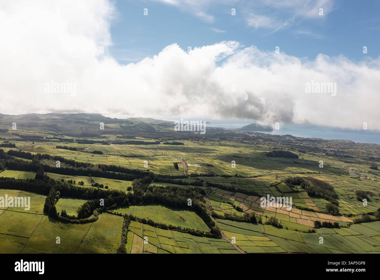 Vista aerea dei lussureggianti campi di patchwork verdi sotto un cielo nuvoloso, Santa Barbara, Azzorre, Portogallo. Foto Stock