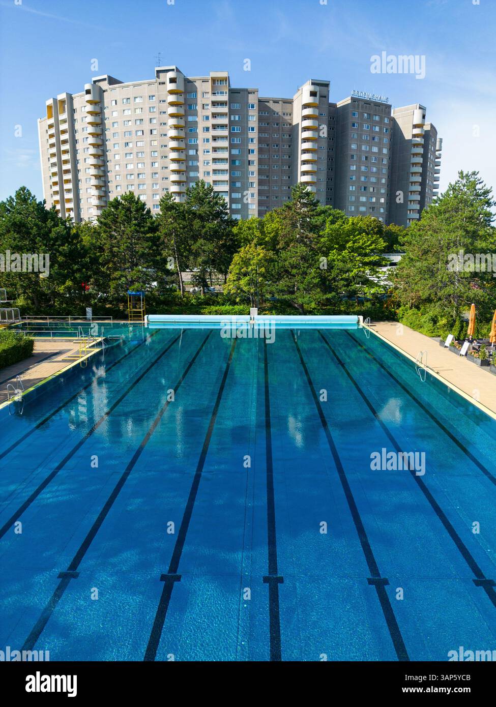 Vista aerea delle piscine pubbliche e degli appartamenti moderni circondati da vegetazione e alberi, Gropiusstadt, Berlino, Germania. Foto Stock