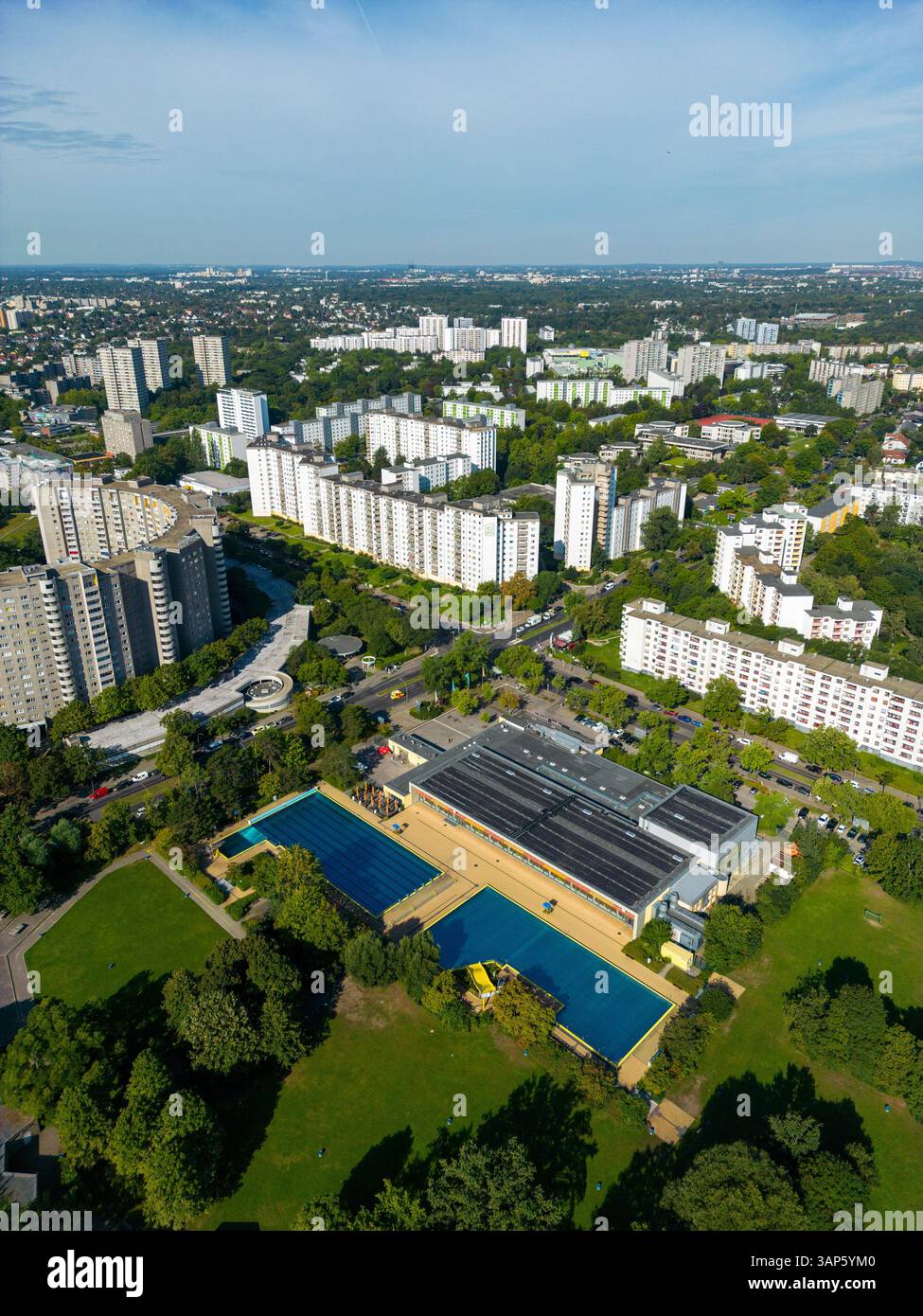 Vista aerea degli edifici residenziali e delle piscine pubbliche circondate da vegetazione e alberi, Gropiusstadt, Berlino, Germania. Foto Stock