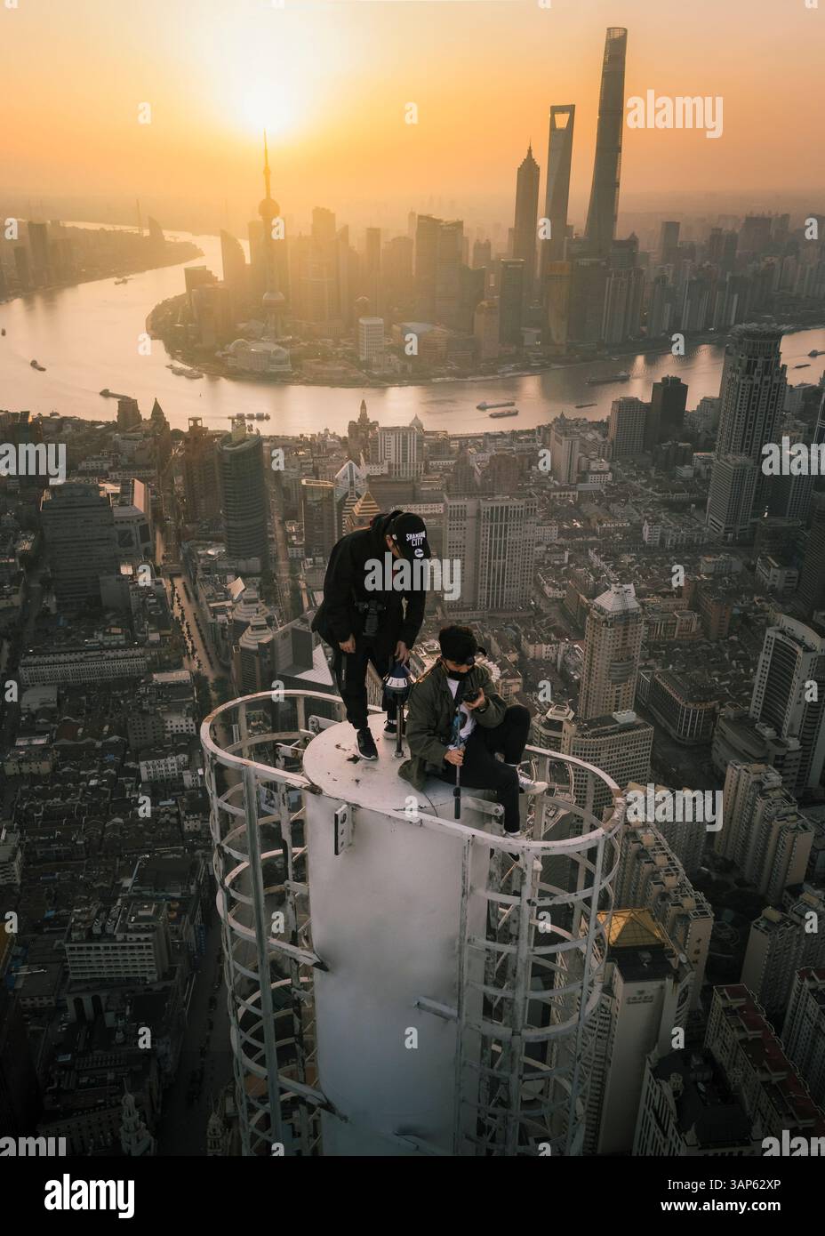 Shanghai, Cina - 27 aprile 2019: Veduta aerea di due giovani in piedi sulla cima di un grattacielo con Shanghai con lo skyline della città sullo sfondo su Foto Stock