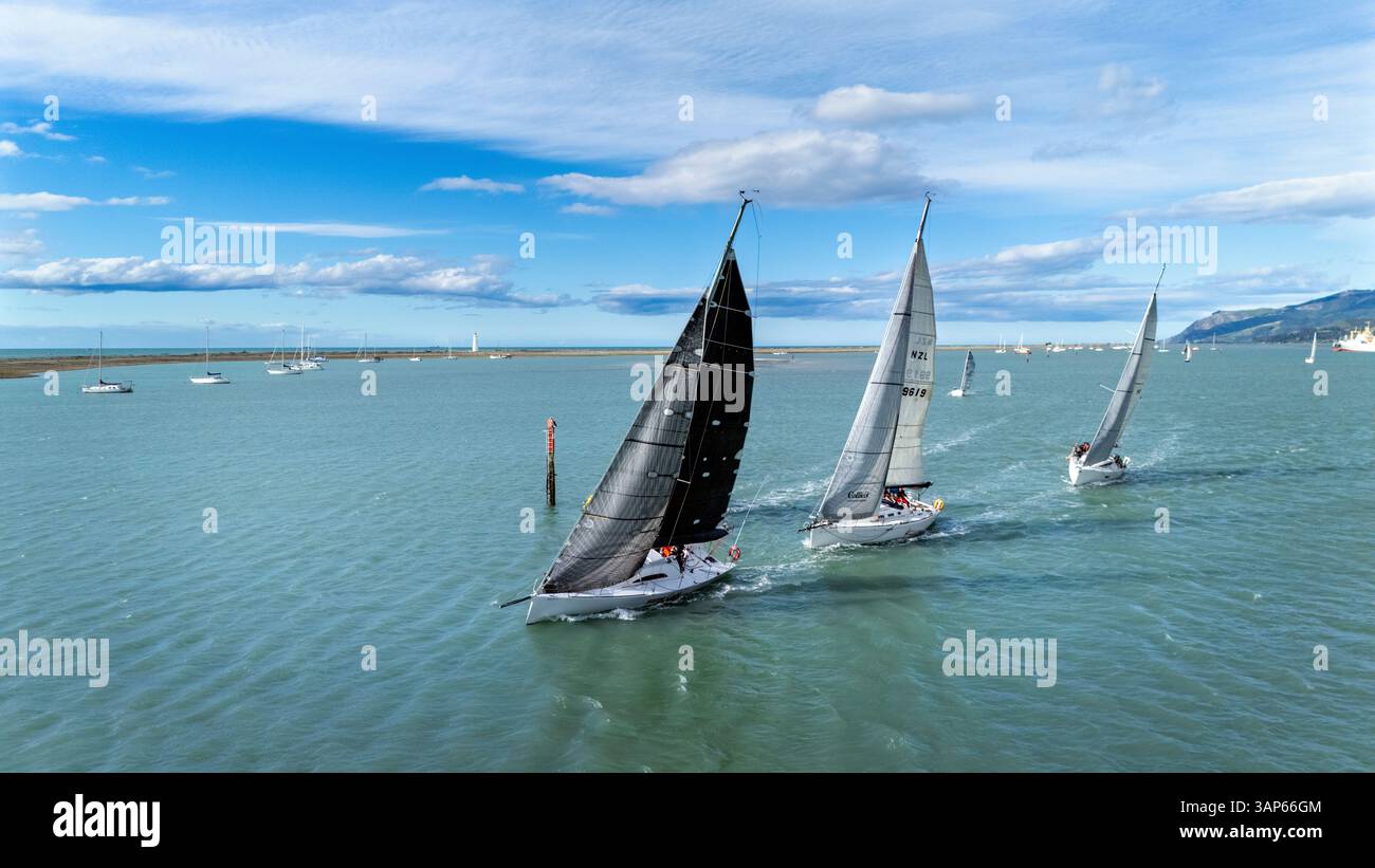 Nelson, nuova Zelanda - 20 novembre 2024: Veduta aerea delle barche a vela che corrono sullo splendido oceano sotto un cielo blu con nuvole, Stepneyville, Nelson, New Foto Stock