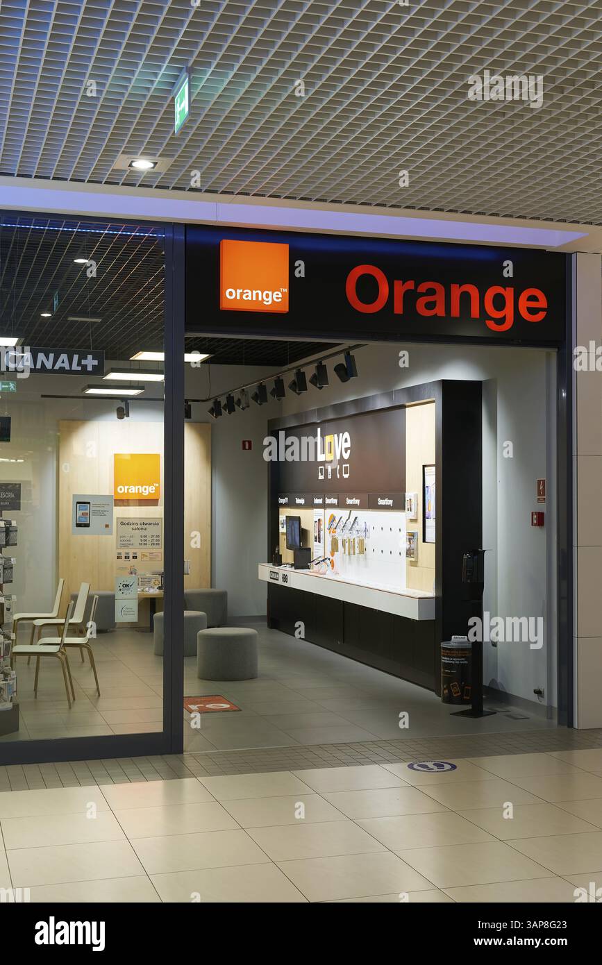 Pubblicità illuminata per la società francese di telecomunicazioni Orange in una filiale in Polonia Foto Stock