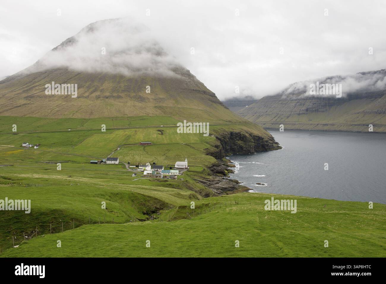 Paesaggio tipico delle Isole Faroe, con erba verde, rocce e acqua vicino a Vidareidi, Vidareidi, Isole Faroe, Danimarca, Europa Foto Stock