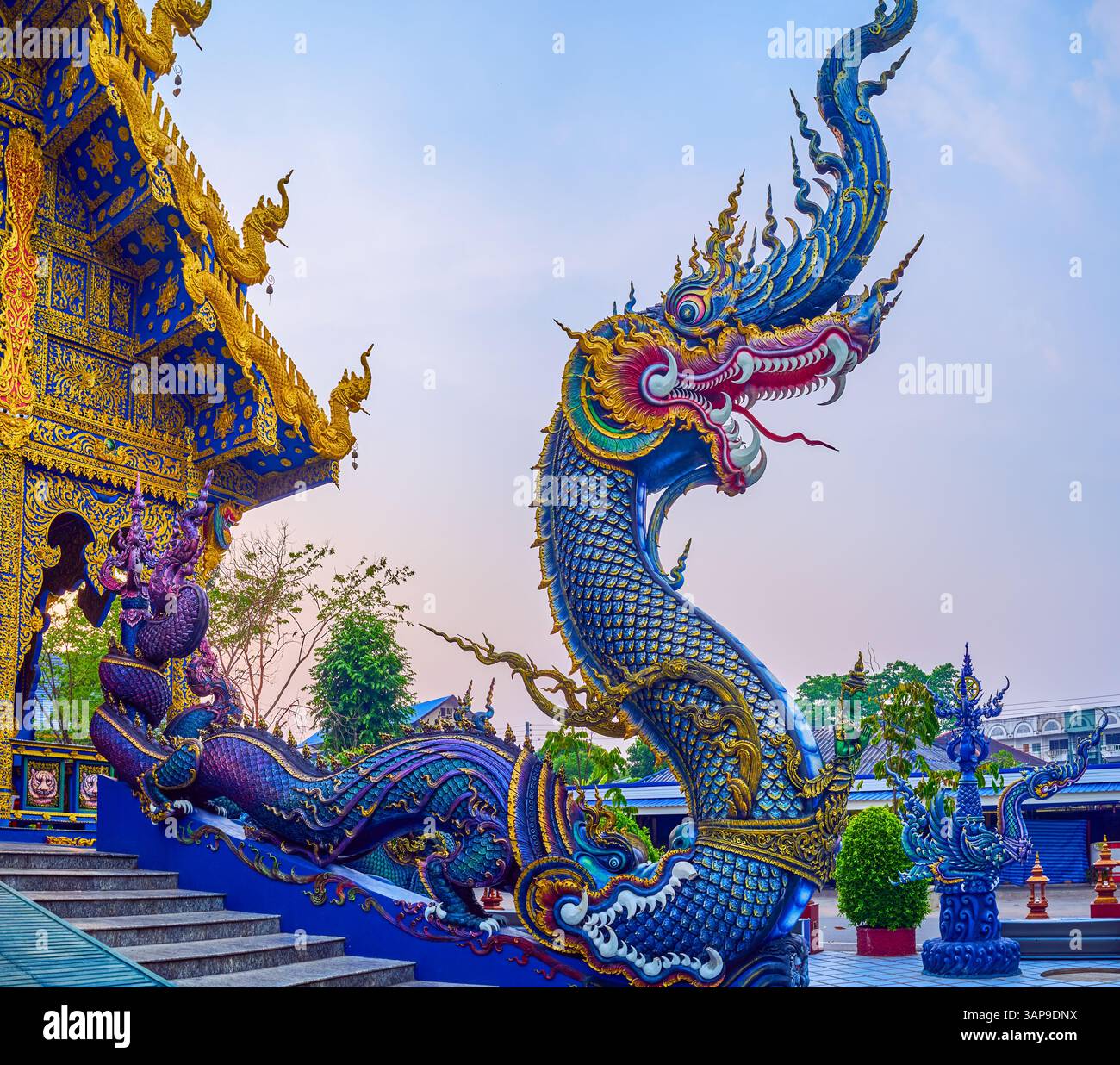 Serpenti colorati di Naga all'ingresso di Ubosot di Wat Rong Suea Ten (Tempio Blu), Chiang Rai, Foto Stock