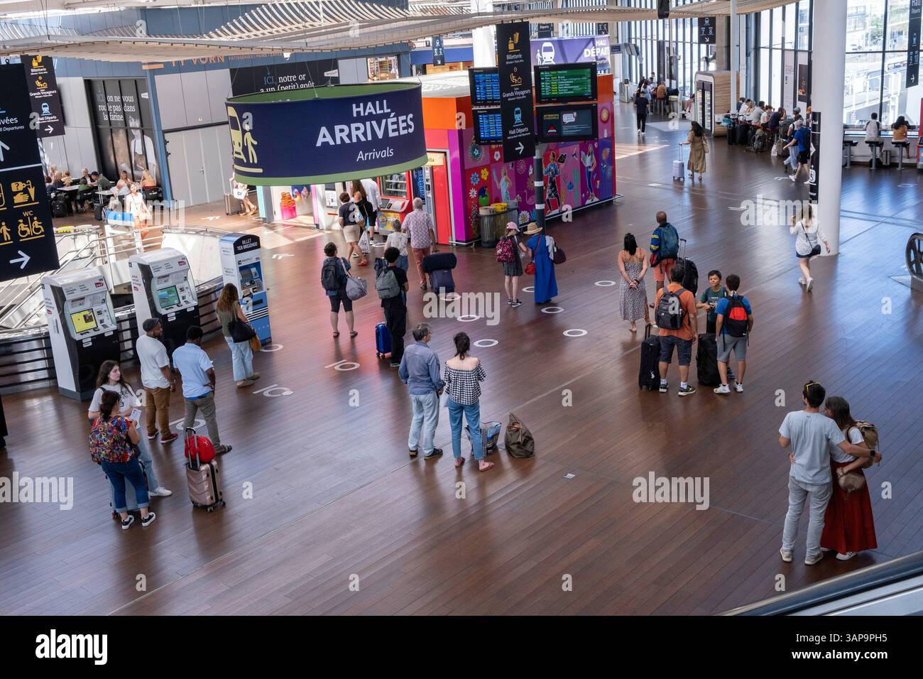 Rennes (Bretagna, Francia nord-occidentale): Turisti in attesa nella sala degli arrivi della stazione. Passeggeri davanti agli schermi che mostrano treno e. Foto Stock