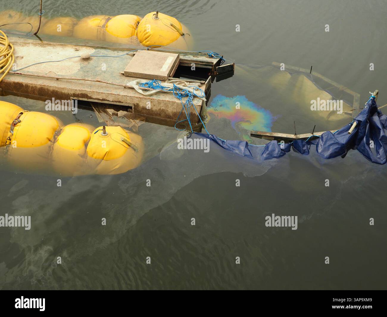 Inquinamento da gasolio o petrolio sul fiume Avon, Bath crea un modello arcobaleno man mano che la barca sommersa viene rigalleggiata. Inquinamento fluviale. Salvataggio marino. Foto Stock