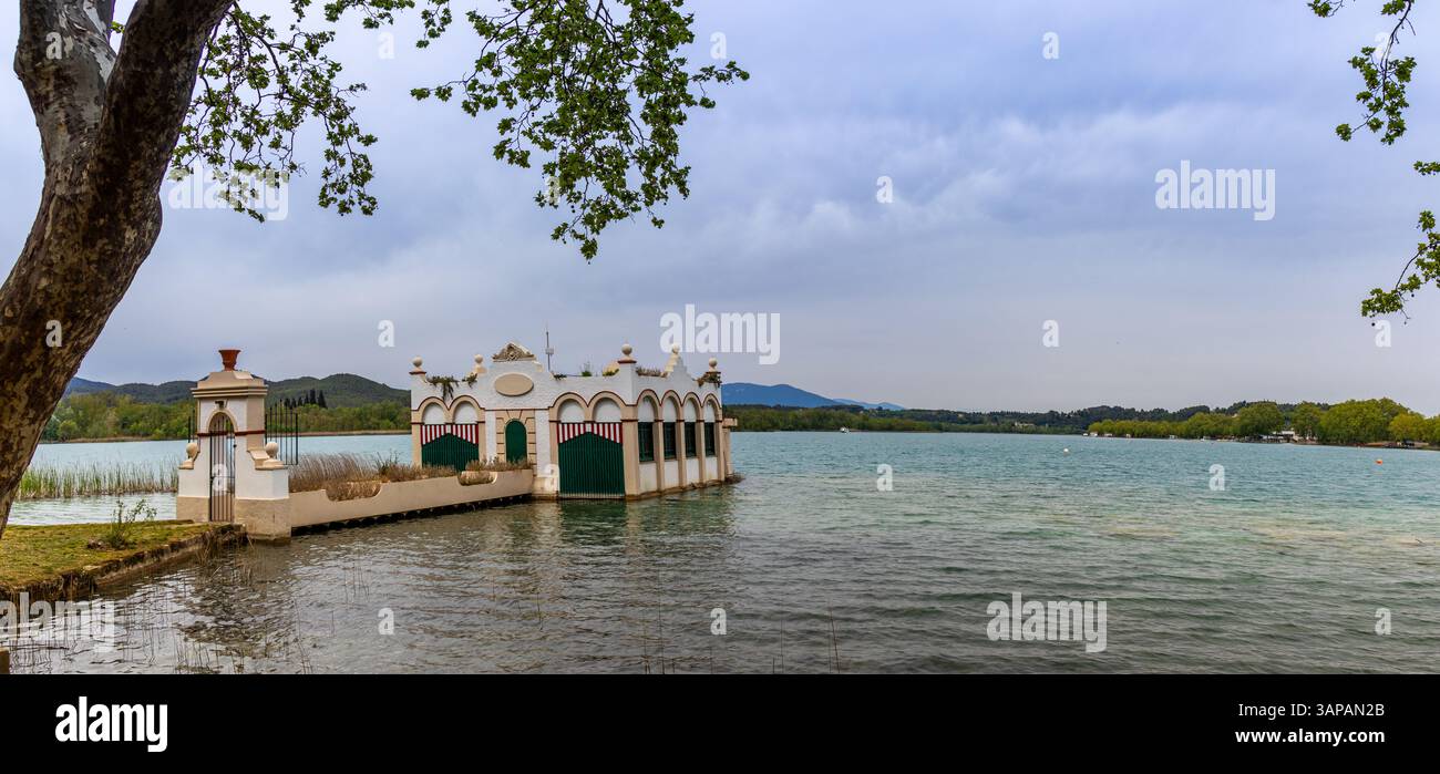 Embarcadero en el lago de Banyoles. El muelle se adentra en las Tranquilas aguas del lago, reflejando el cielo y la vegetación. Girona, España Foto Stock