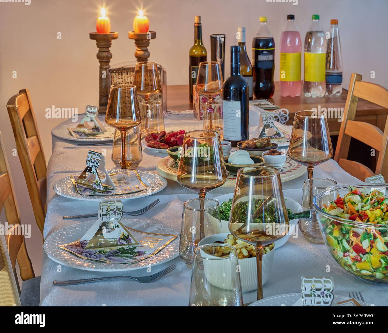 Festa pasquale allestita con matzah, erbe simboliche e piatti cerimoniali su un tavolo festivo di seder splendidamente decorato. Foto Stock