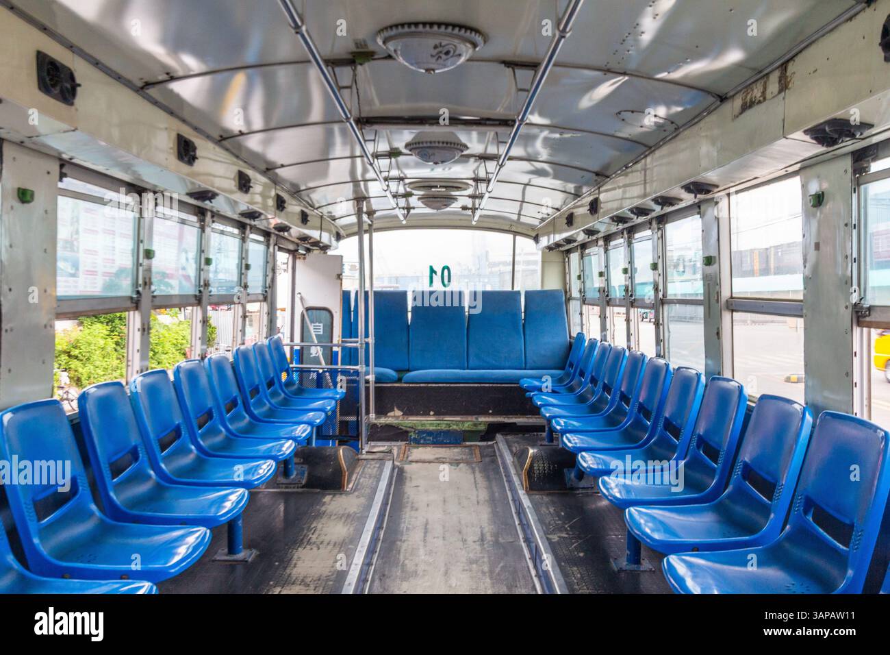 Interno di un piccolo autobus locale con sedili blu che trasporta passeggeri dal terminal alla nave presso un molo di Cebu, Filippine Foto Stock