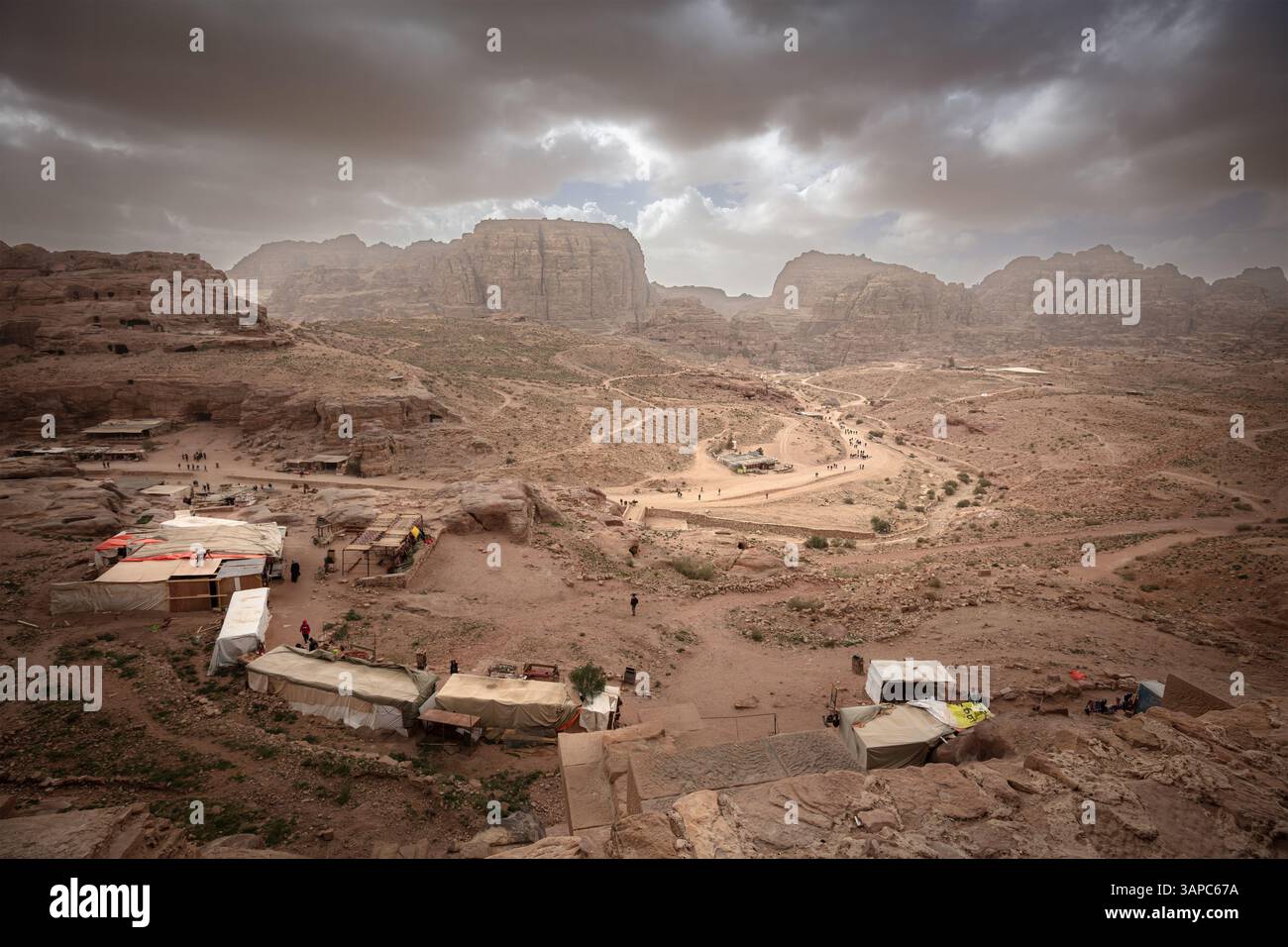 Spettacolari nuvole che si radunano sulla valle di petra in giordania con bancarelle di souvenir Foto Stock