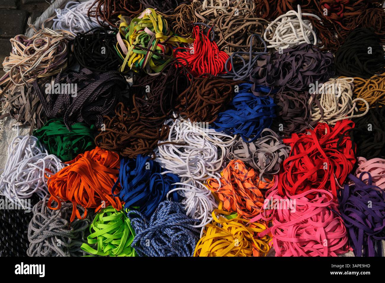 Accra, Ghana, Distretto di Jamestown. Lacci per scarpe in vendita da parte del fornitore del marciapiede. Foto Stock