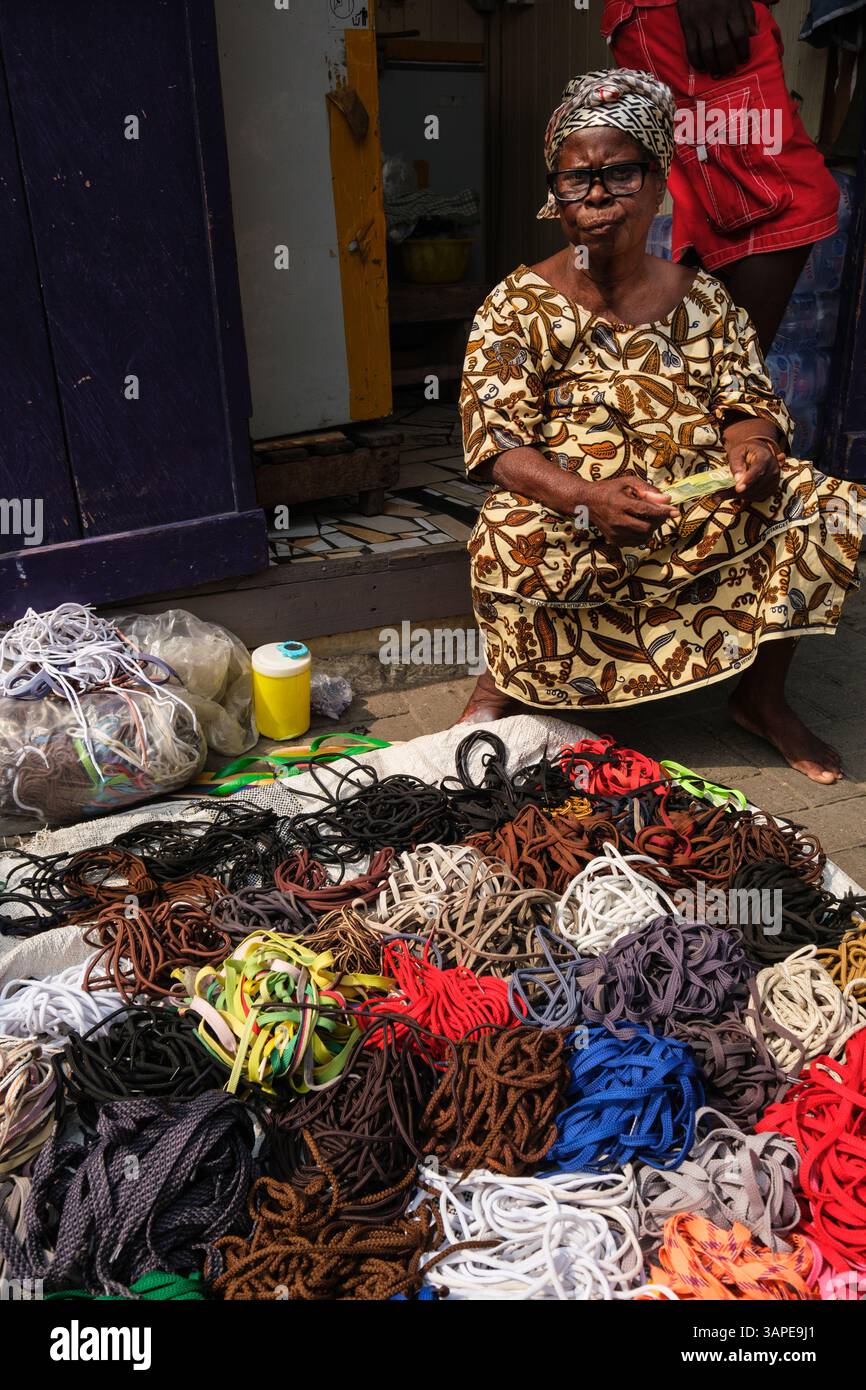 Accra, Ghana, Distretto di Jamestown. Venditore marciapiede, donna che vende lacci. Foto Stock