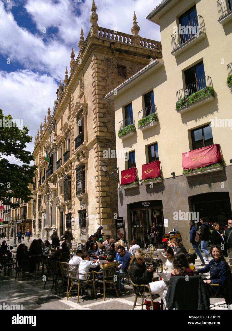 La gente siede in un bar all'aperto in Plaza Nueva, vicino al palazzo della Cancelleria di Granada, Spagna Foto Stock