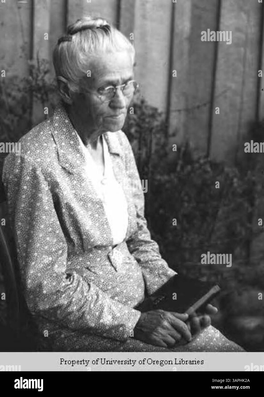 Una fotografia di una donna anziana in possesso di un libro, tratta dalla collezione Doris Ulmann, che riflette un momento tranquillo di studio e di impegno intellettuale. Foto Stock