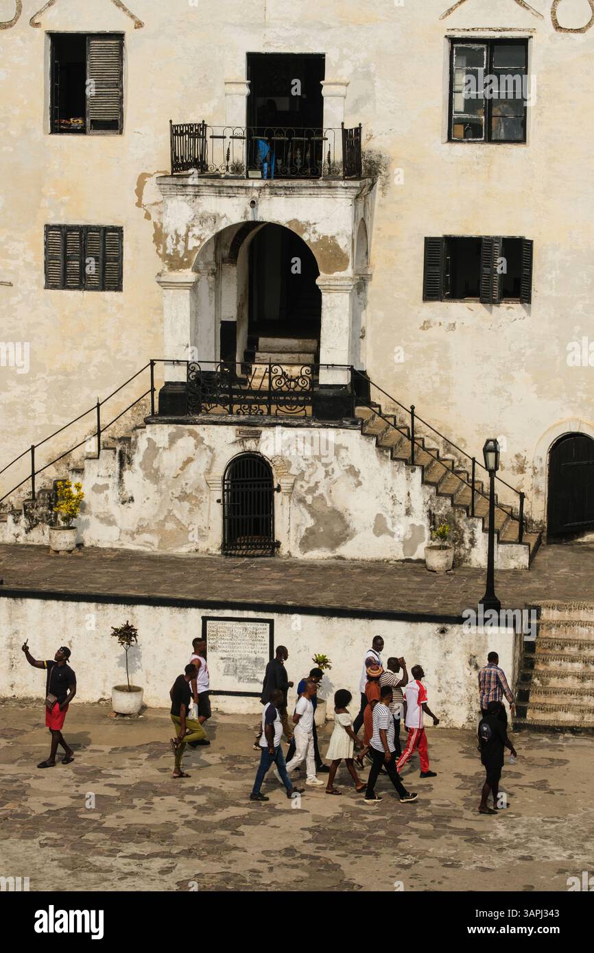 Ghana, Elmina. Castello di San Giorgio, castello di Elmina. Turisti africani nel cortile con guida. Foto Stock