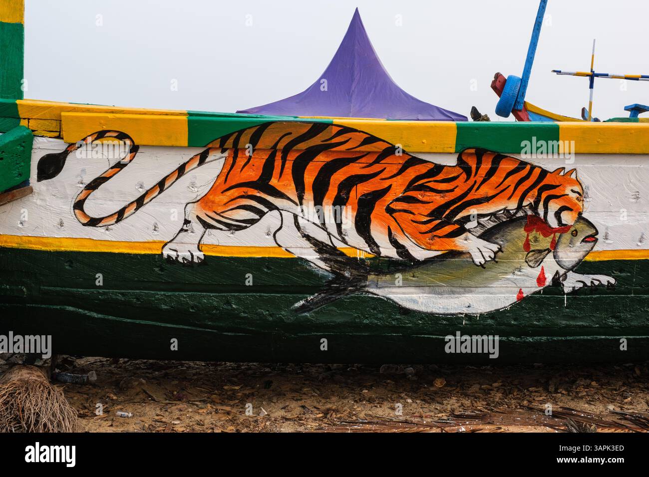 Ghana, Elmina. Disegna su una barca da pesca che mostra una tigre che cattura un pesce. Foto Stock