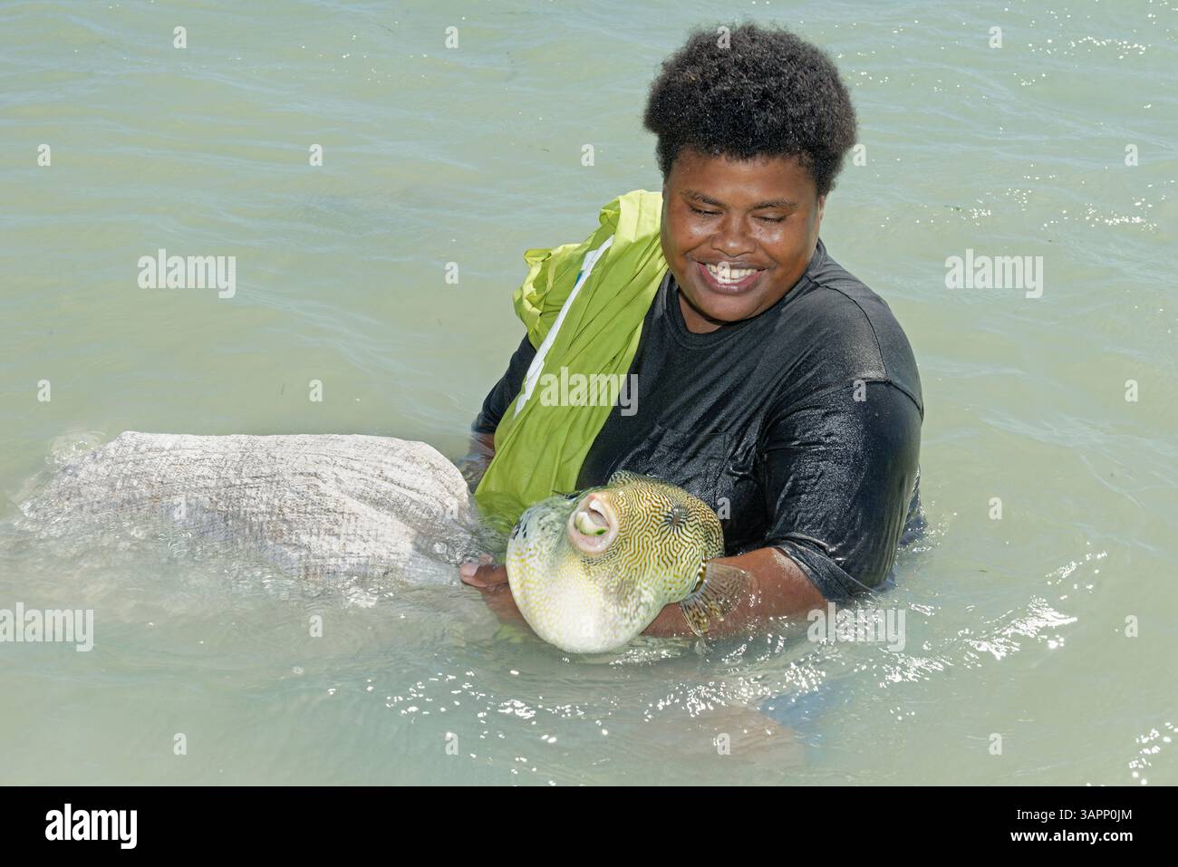 Donna del posto che tiene un pesce grosso, gruppo dell'isola di Yasawa, Figi, Pacifico meridionale Foto Stock
