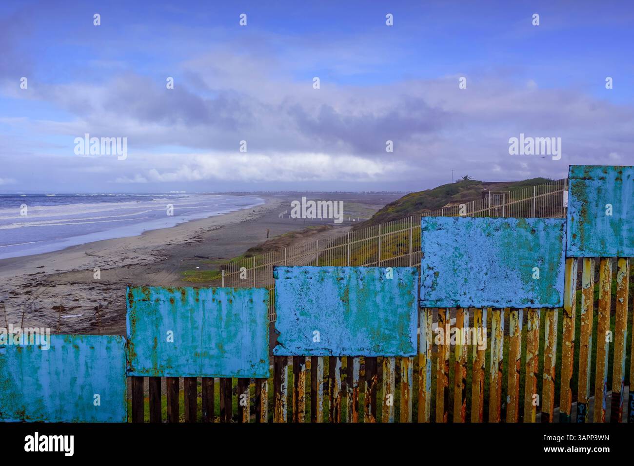 La zona di confine dove gli Stati Uniti incontrano Tijuana, segnata dall'imponente muro di confine (il cosiddetto muro Trump) che si estende sulla spiaggia del Pacifico. Foto Stock
