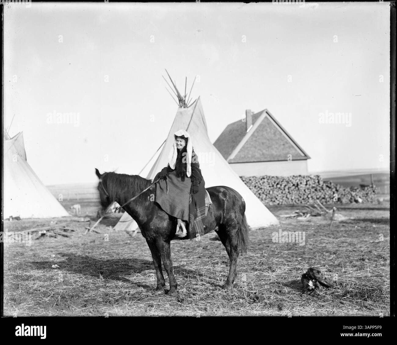 Una fotografia di Lee Moorhouse che mostra una donna nativa americana a cavallo. Questa immagine storica cattura la figura con un abbigliamento tradizionale, mostrando un significativo aspetto culturale del tempo. Foto Stock