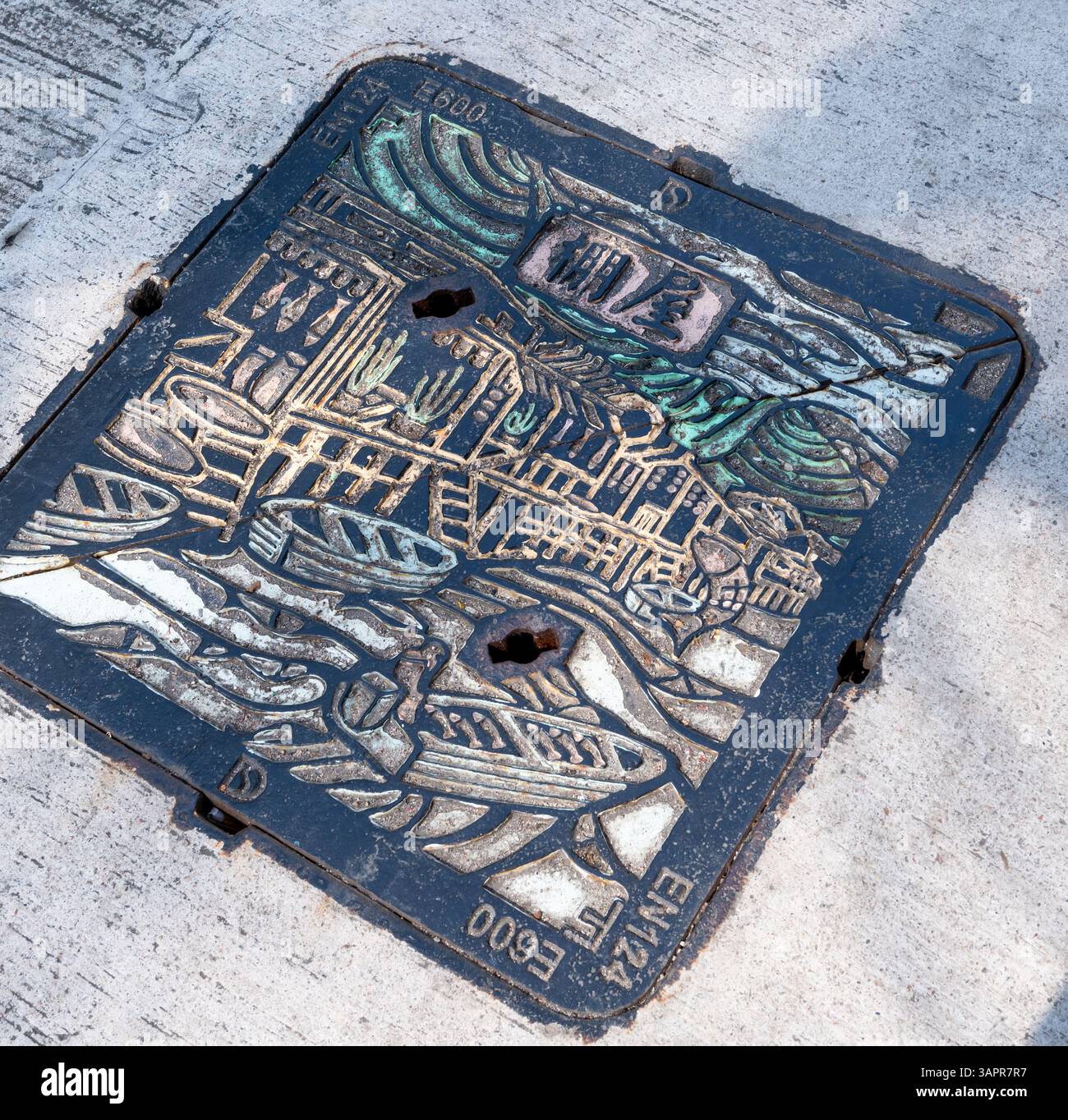Hong Kong. Cina- 02.27.2025. Una copertura per lo scarico della strada nel villaggio di Tai o realizzata in metallo con un disegno artistico del villaggio di pescatori. Foto Stock