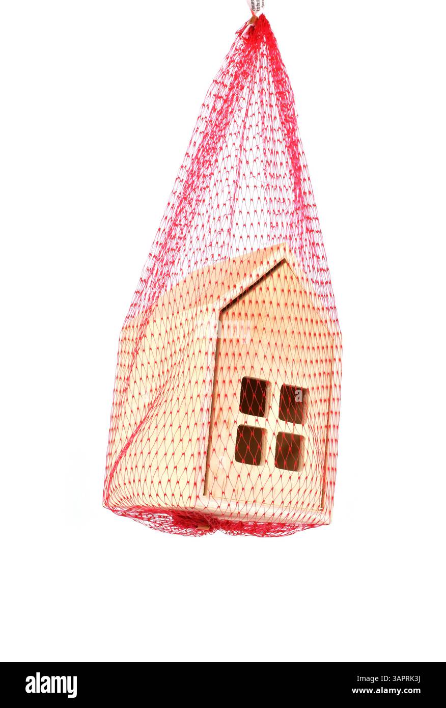 Casa modello sospesa in una rete di sicurezza a maglia rossa. Niente persone. Concetto di rete di sicurezza per gli arretrati di mutui ipotecari. Foto Stock