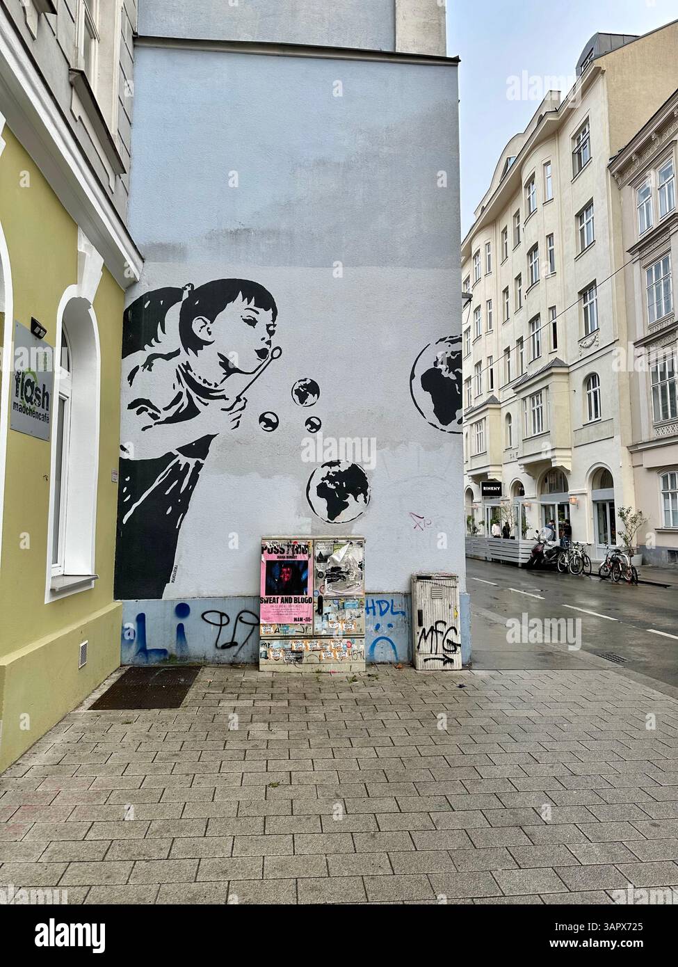 Street art di una ragazza che soffia bolle come il pianeta terra di Mandarina Brausewetter a Zieglergasse, Vienna, Austria - Immagine stock catturata con smartphone