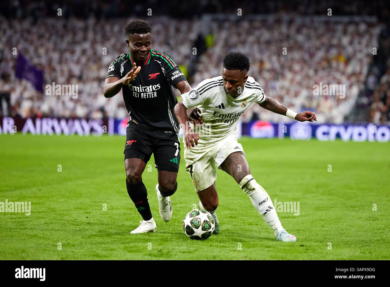 MADRID, SPAGNA - 16 APRILE: Vinicius Junior del Real Madrid compete per il pallone con Bukayo Saka dell'Arsenal FC durante la partita di secondo livello di UEFA Champions League 2024/25 tra il Real Madrid C.F. e l'Arsenal FC all'Estadio Santiago Bernabeu il 16 aprile 2025 a Madrid, Spagna. (Foto di QSP) credito: QSP/Alamy Live News Foto Stock