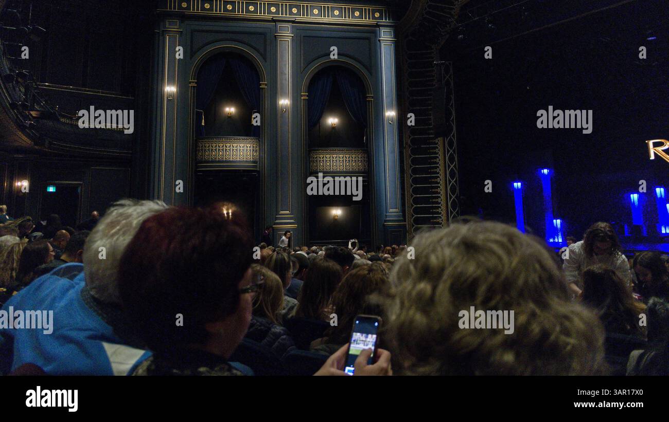 Un elegante interno del teatro pochi istanti prima dell'iconico spettacolo Riverdance. La folla sta riempendo i sedili, i telefoni sono spenti e il glowin Foto Stock