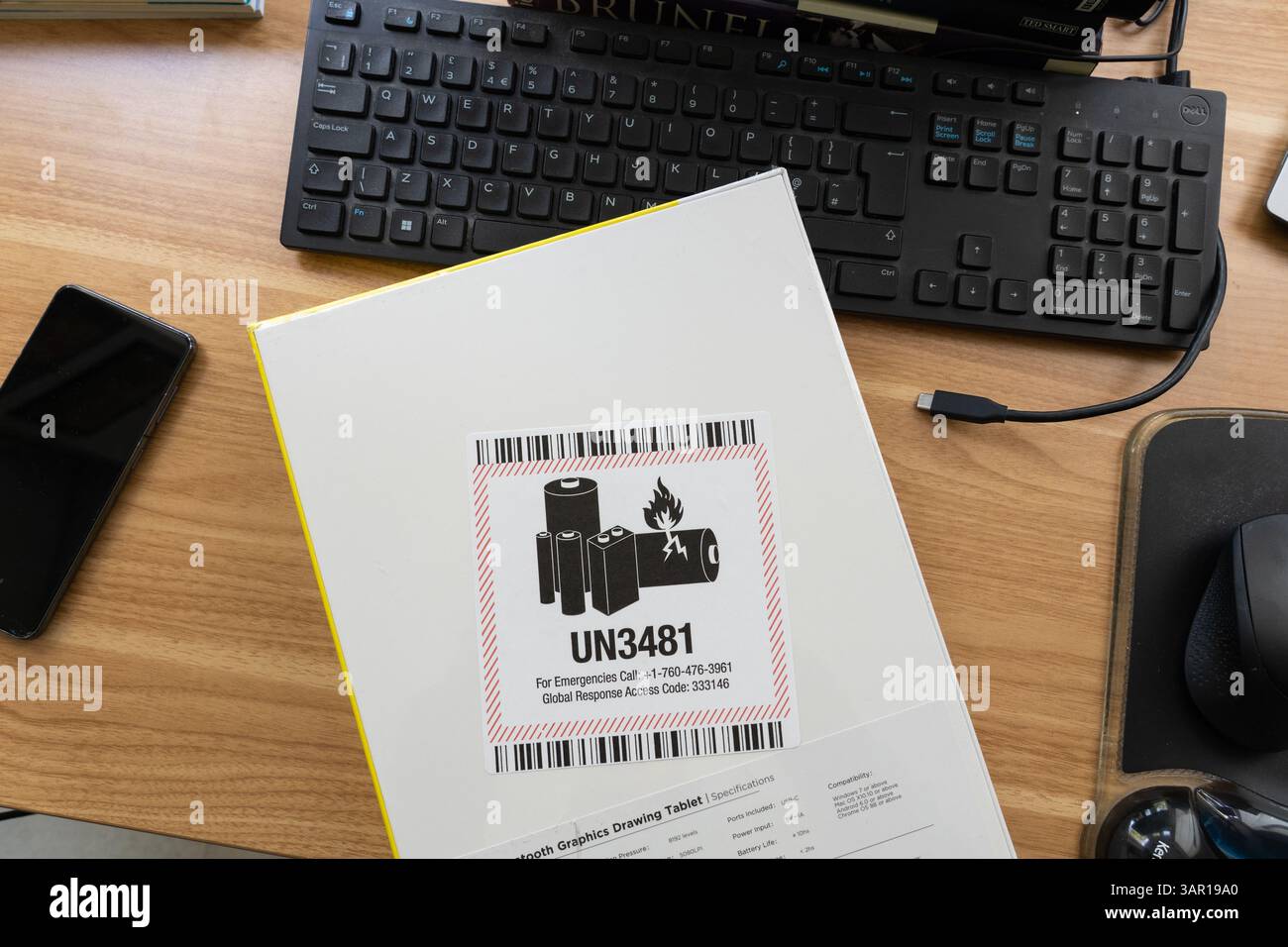 Pacchetto con tavoletta grafica contenente batterie agli ioni di litio con etichetta UN3481 che indica le batterie come merci pericolose contenute nell'apparecchiatura. REGNO UNITO Foto Stock