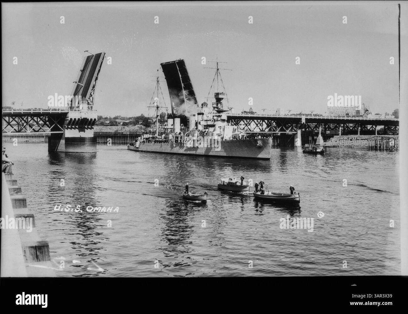 Questa fotografia in nitrato cattura la USS Omaha vicino a un ponte levatoio, mostrando un momento storico nel trasporto navale. Foto Stock
