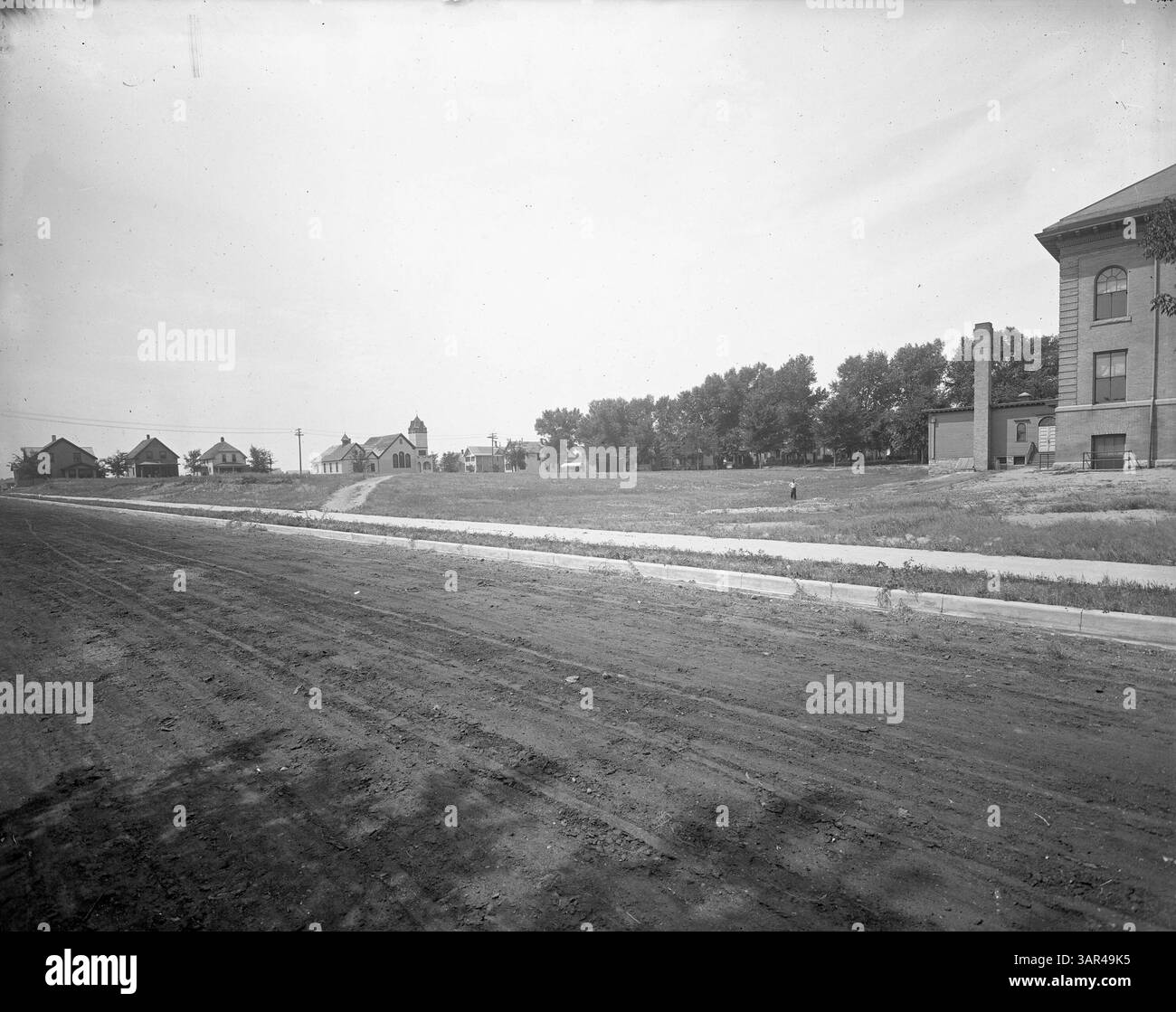 Questa foto mostra la prima Bryant School, in seguito rinominata Warrington nel 1927. Documenta le condizioni del terreno scolastico e dell'area circostante, con la 38esima chiesa di S. Congregazione visibile in lontananza. Foto Stock