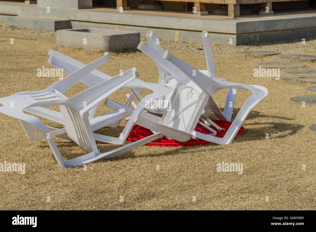 Sedie in plastica bianca girate sopra il tavolo in plastica rossa. Chungju, Corea del Sud. 24 febbraio 2021 Foto Stock