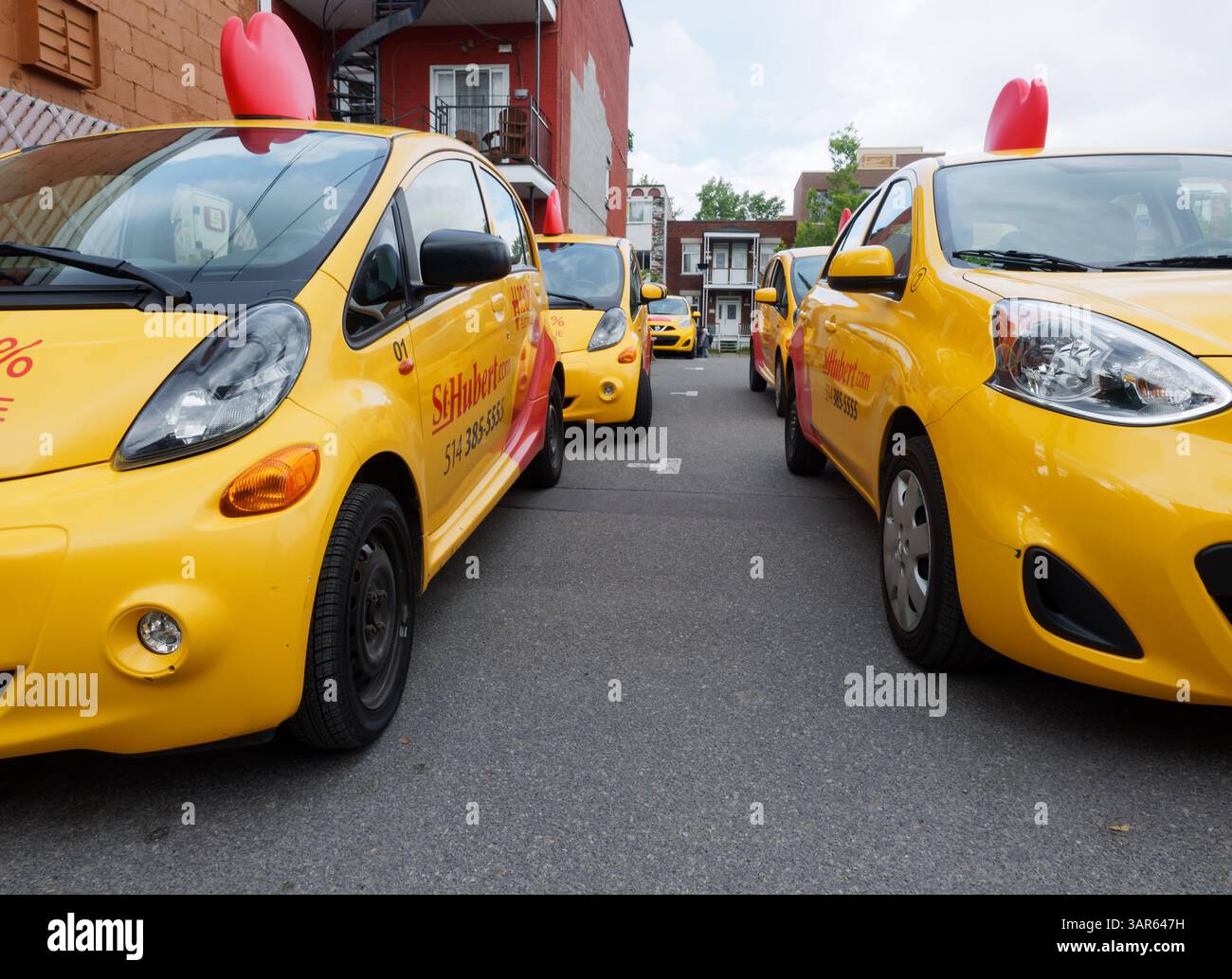Una fila di auto di consegna del barbecue di St-Hubert a Montreal Foto Stock