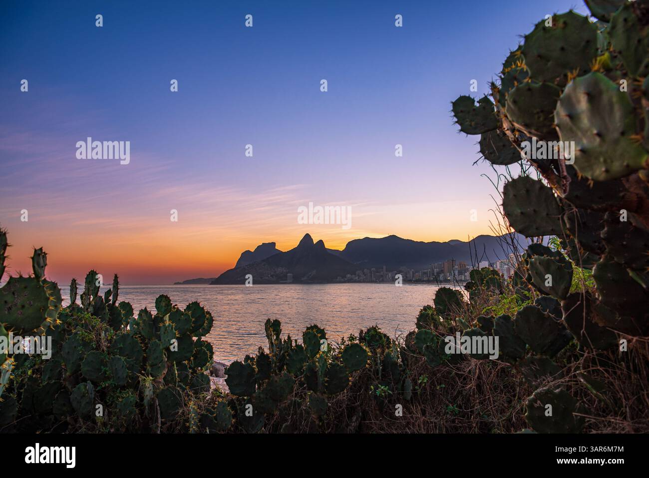 Tramonto incorniciato sulla spiaggia di Ipanema da Pedra do Arpoador - Rio de Janeiro, Brasile Foto Stock