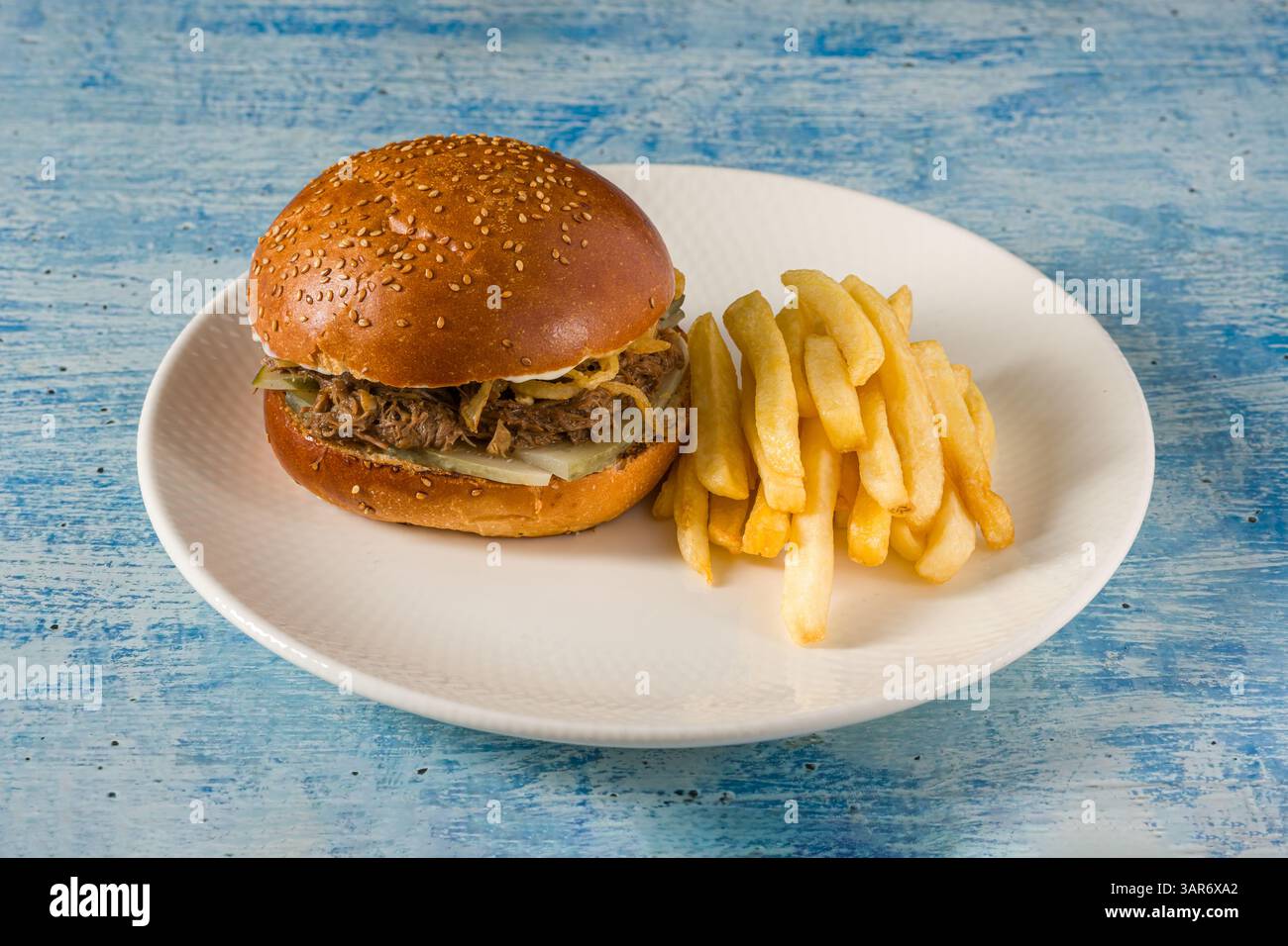 Hamburger di cavolo a cottura lenta con patatine fritte su un piatto di porcellana bianca Foto Stock