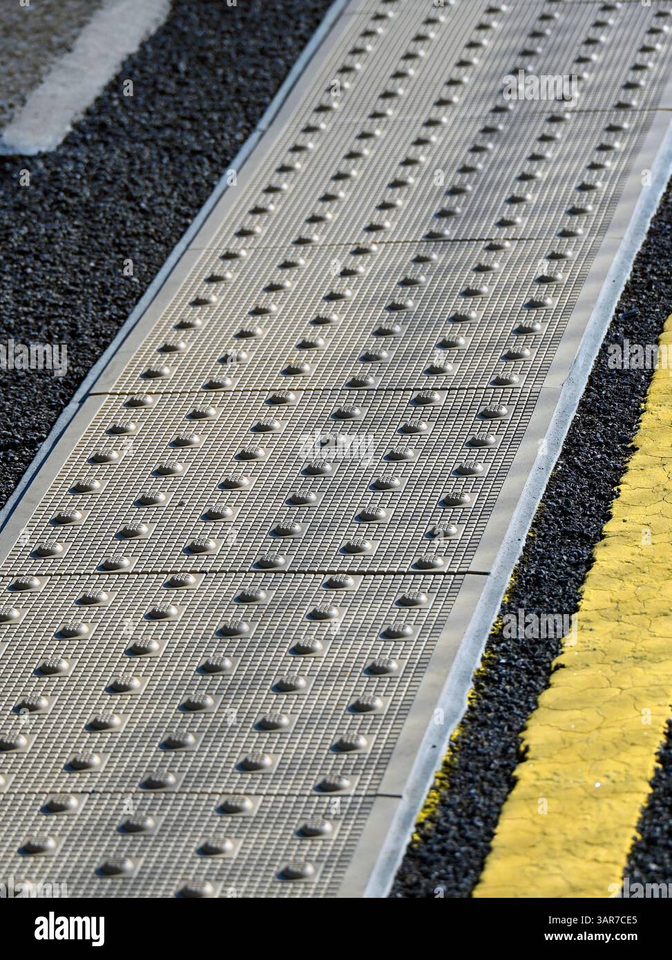 Pavimentazione tattile sulla piattaforma della stazione. Stazione ferroviaria di Oxenholme, West Coast Main Line, Cumbria, Inghilterra, Regno Unito, Europa. Foto Stock